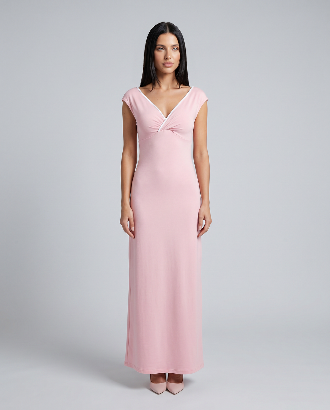 Woman wearing a pink off shoulder maxi dress with ruched waist on a plain background.