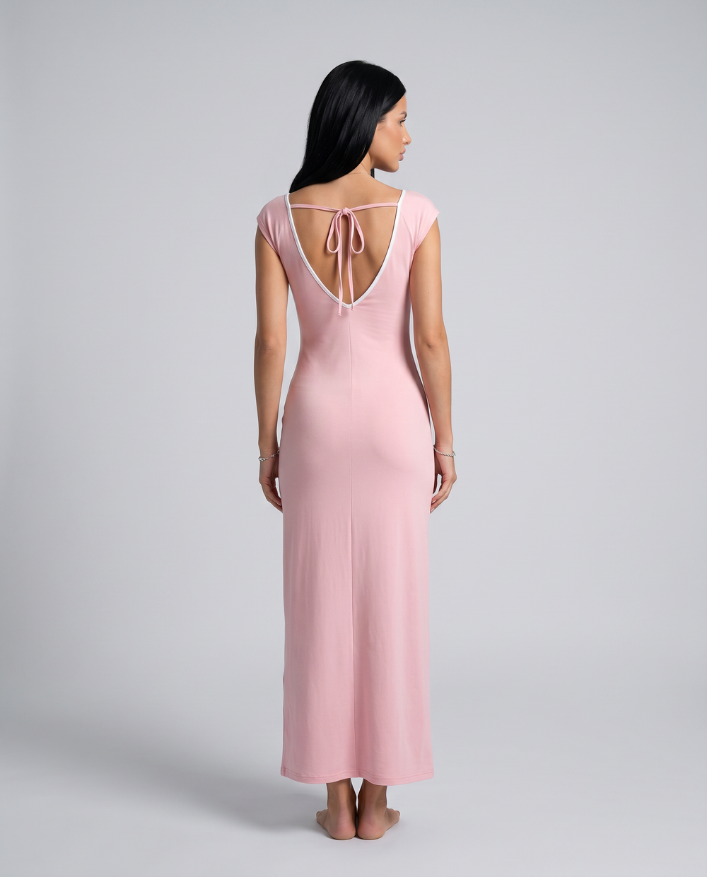 Female model in a pink off shoulder formal maxi dress on a plain background.