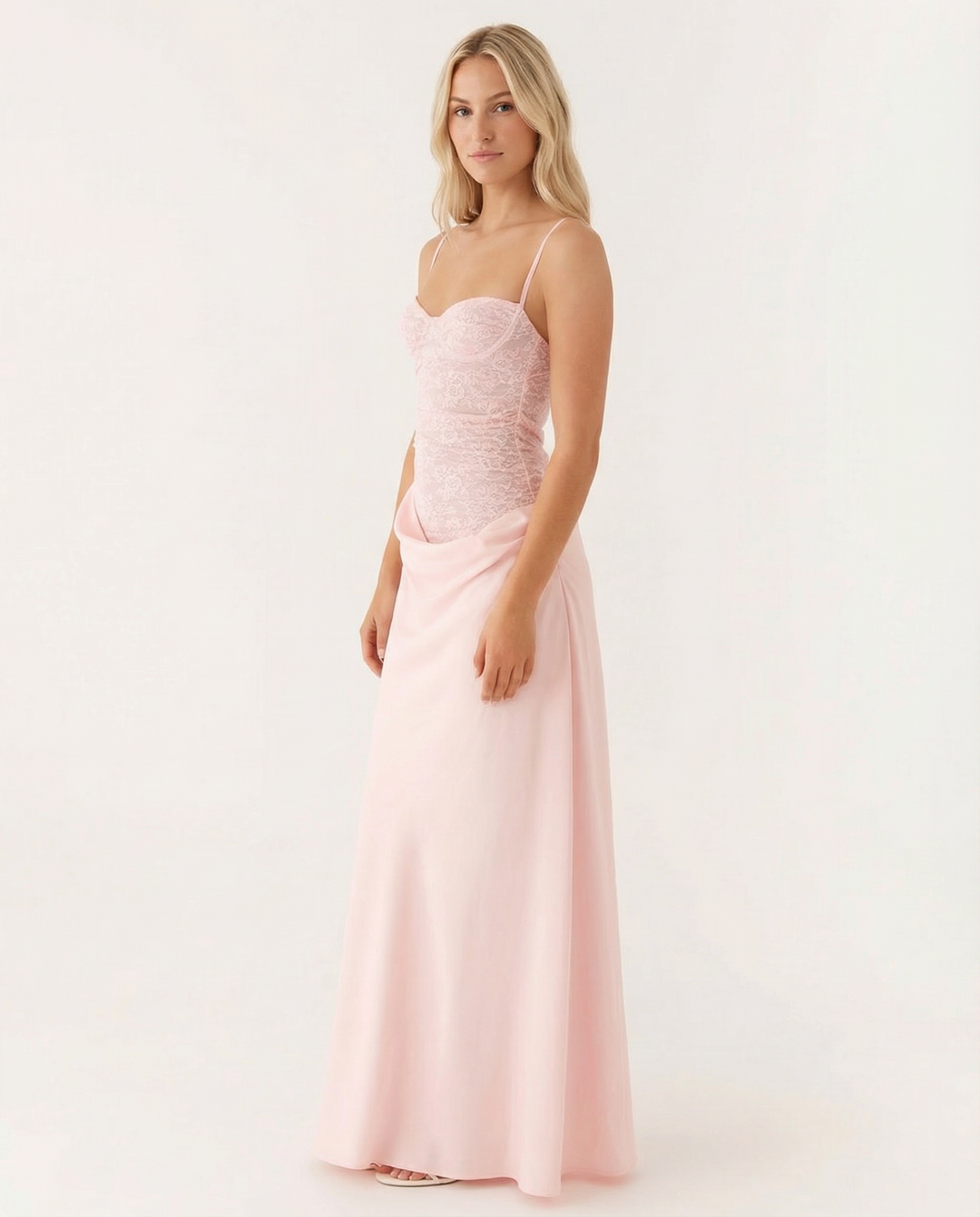 Woman wearing a sleeveless maxi dress with gathered bust detail and soft draping on a plain background.