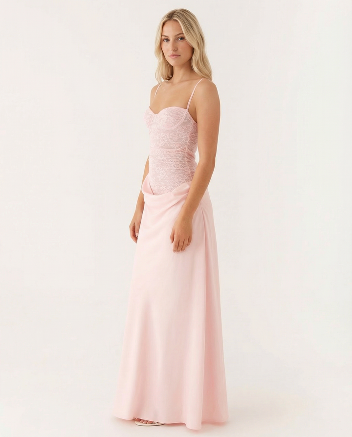 Woman wearing a sleeveless maxi dress with gathered bust detail and soft draping on a plain background.