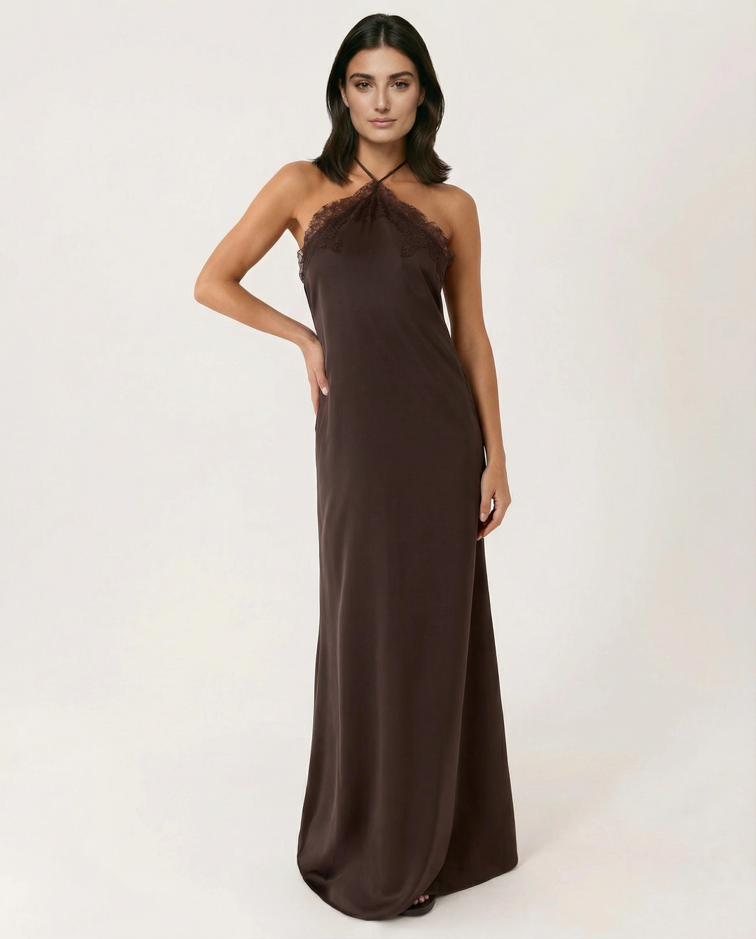 Model wearing a sleeveless halter maxi dress in chocolate on a plain background.