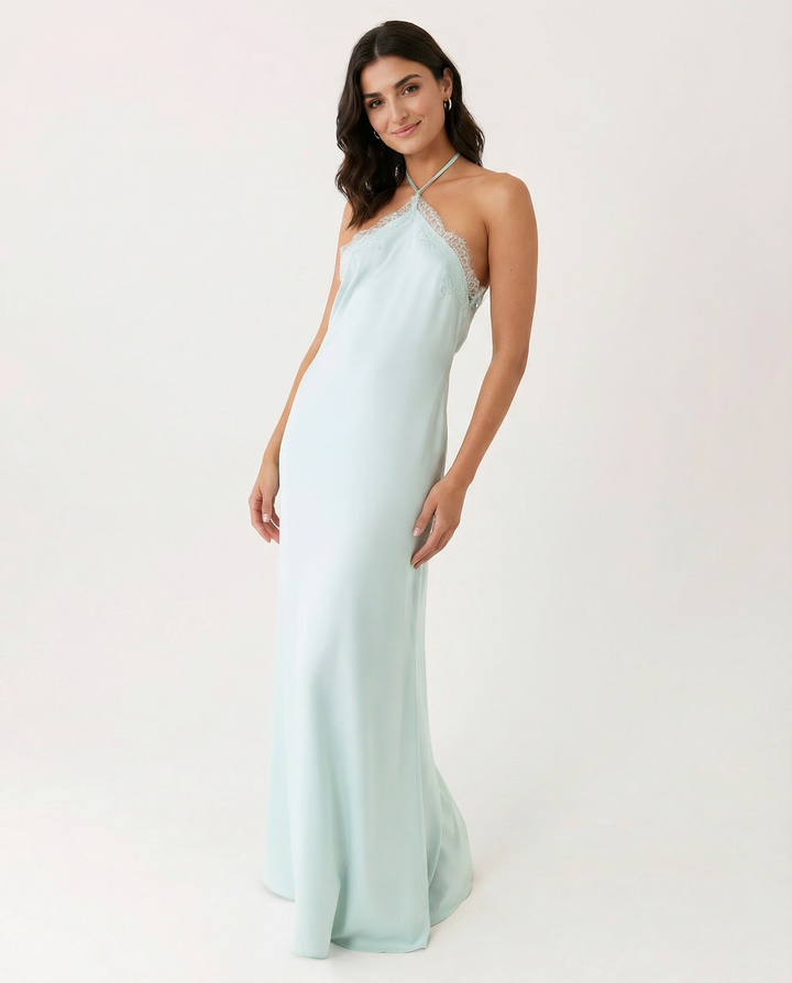 Female model in a full-length blue dress with lace trim neckline on a plain background.