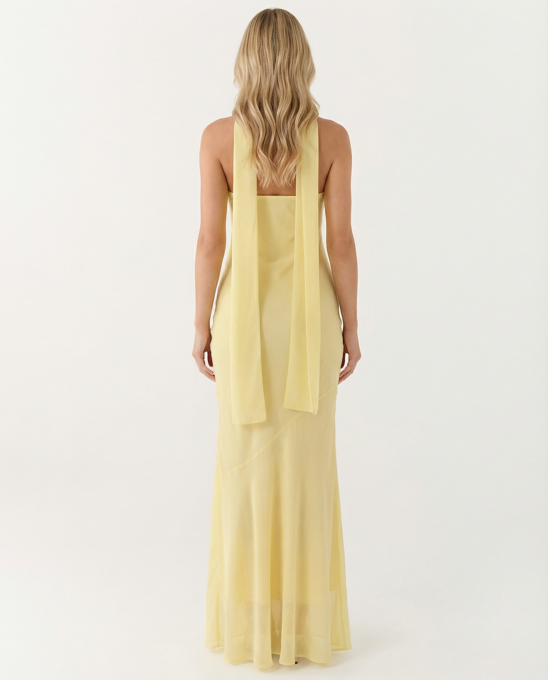 Woman wearing an apricot floral maxi dress on a plain background.