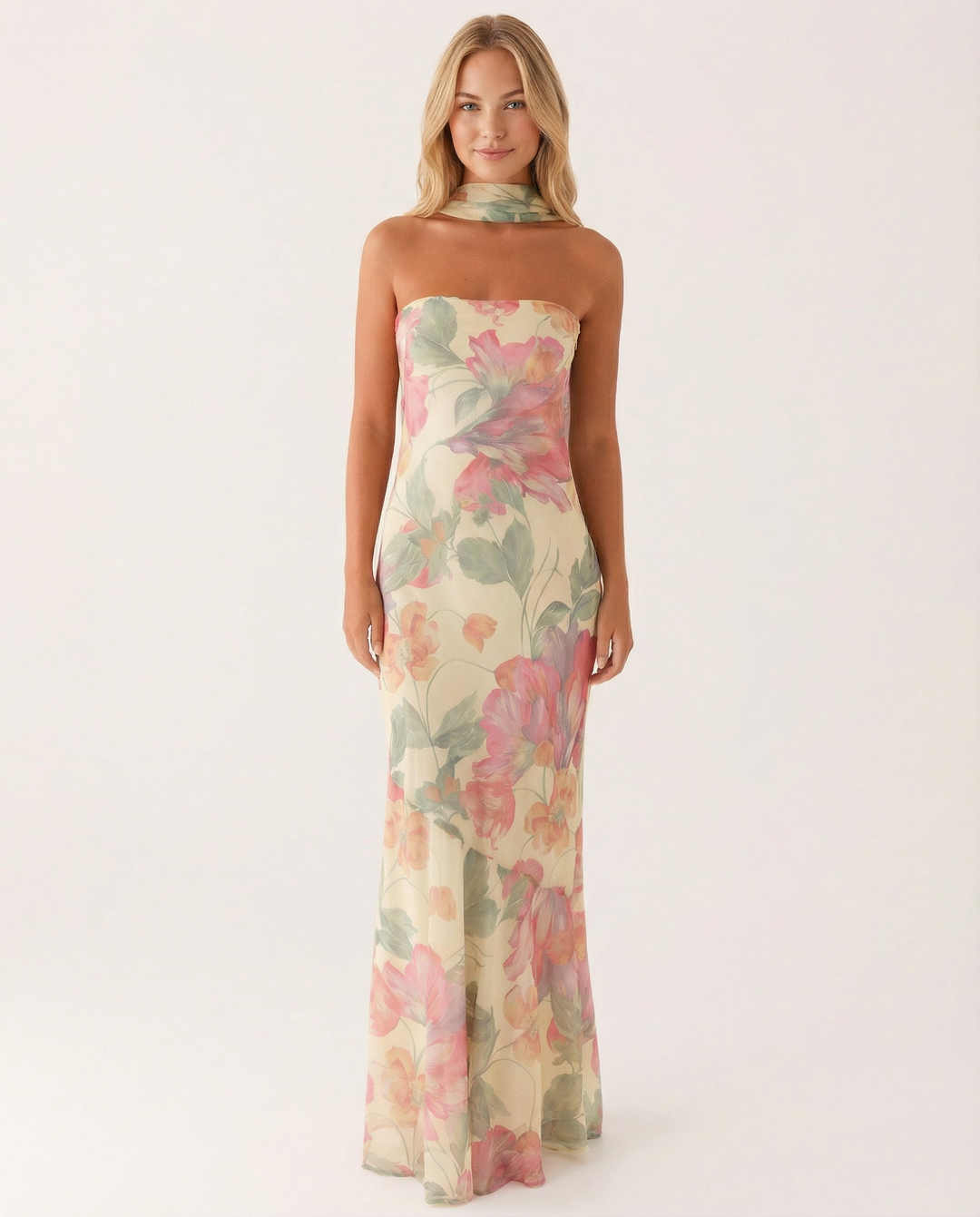 Woman wearing a strapless floral maxi dress on a plain background.