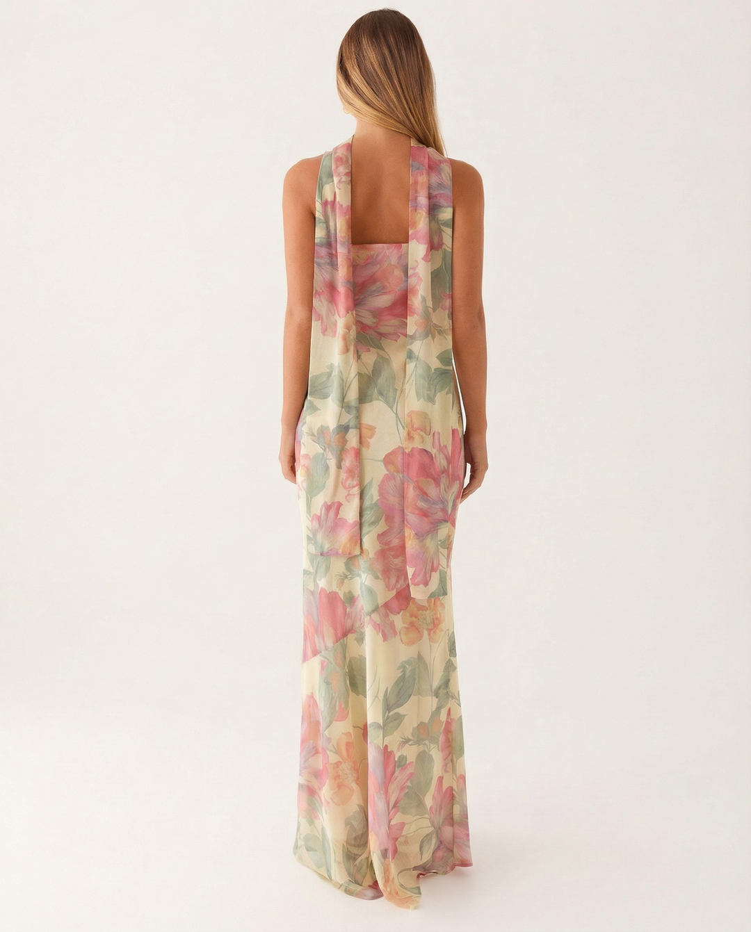Female model in a flowing floral strapless dress with an asymmetrical hem.