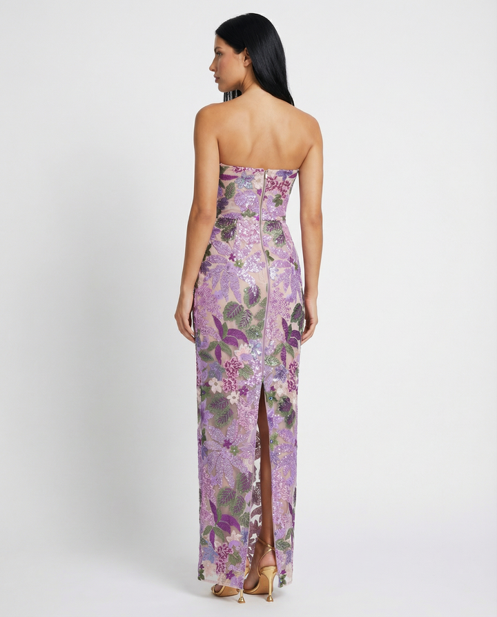 Female model in a purple sequin embroidered maxi dress with sweetheart neckline on a plain background.