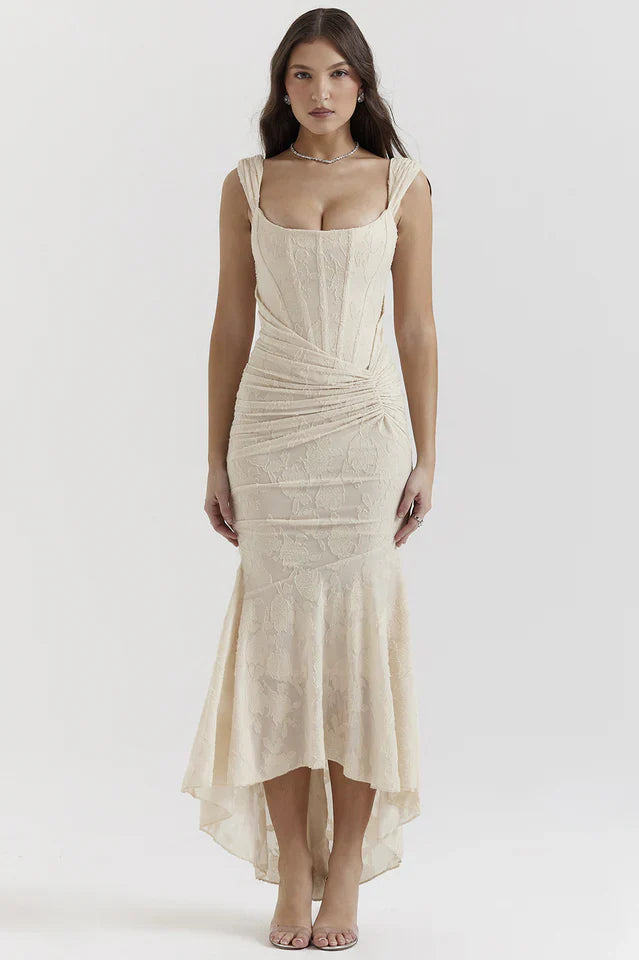 Woman wearing a textured maxi dress with wide straps on a plain background.