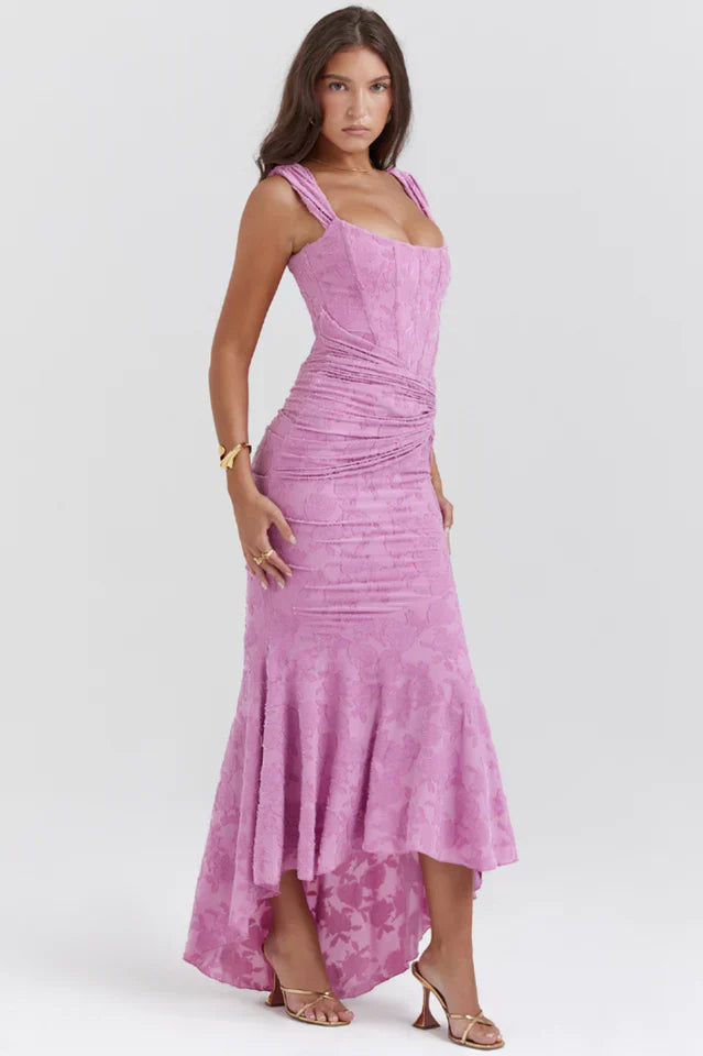 Model wearing a rose pink dress with sculpted bodice and flared hem.