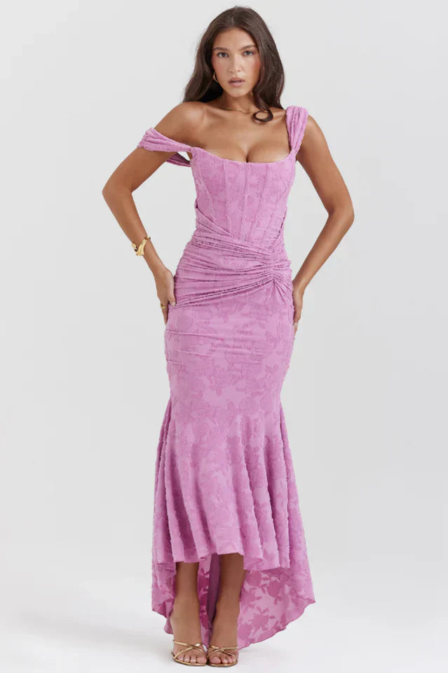 Model wearing a rose pink maxi dress with flowing skirt against a plain background.