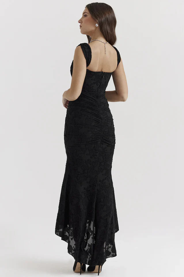 Woman wearing a maxi dress with square neckline on a plain background.