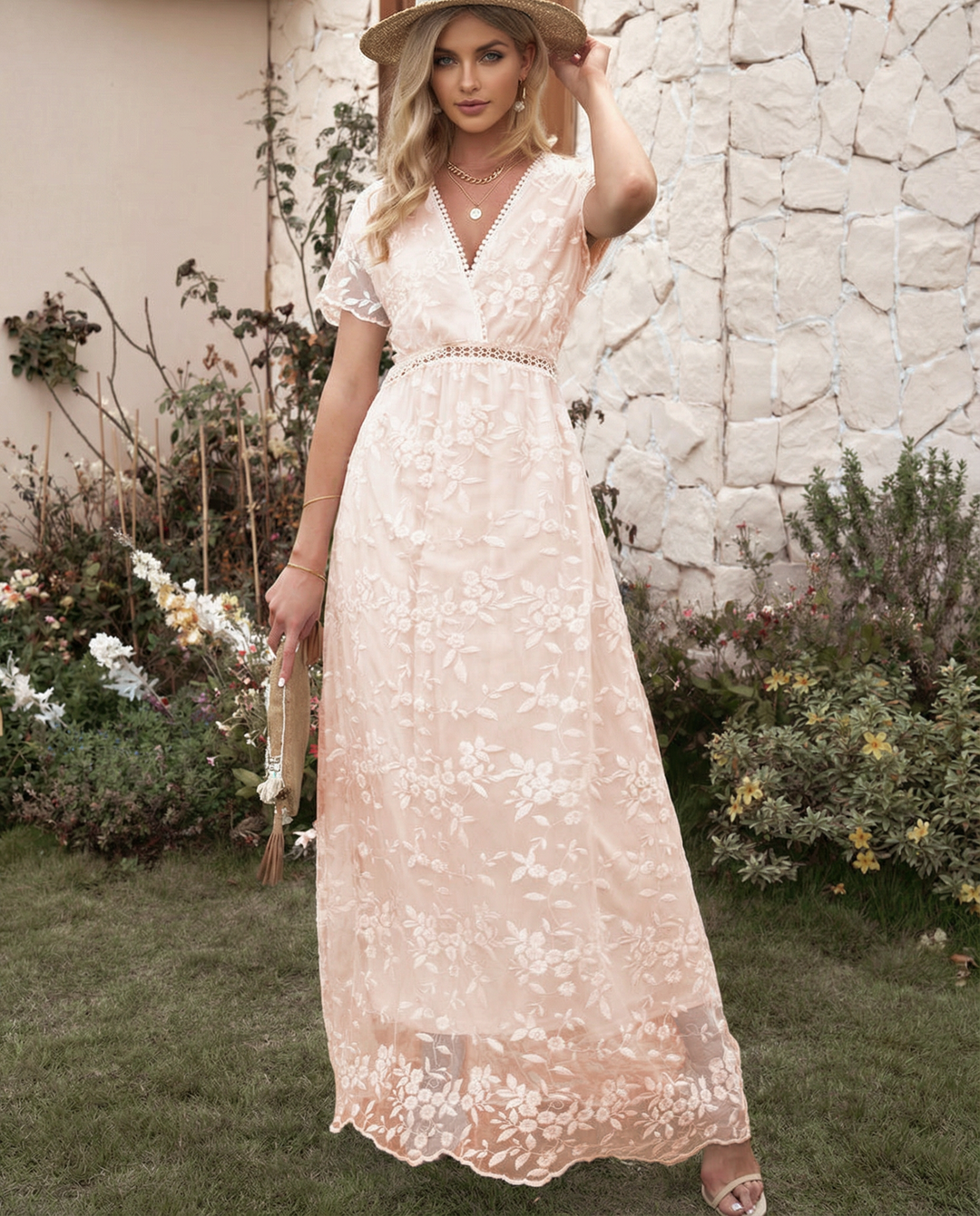 Woman in a long floral dress with a defined bodice against a plain background.