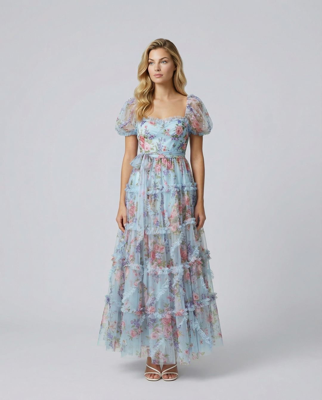 Model wearing a floral tiered maxi dress with puff sleeves against a plain background.