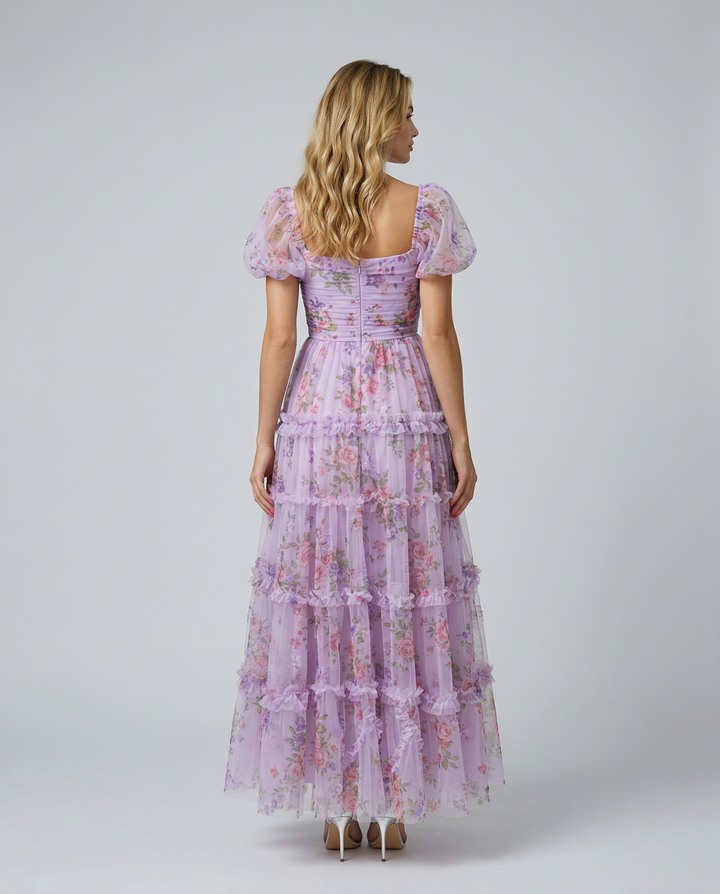 Female model wearing a square neck floral maxi dress with flowing layered skirt.