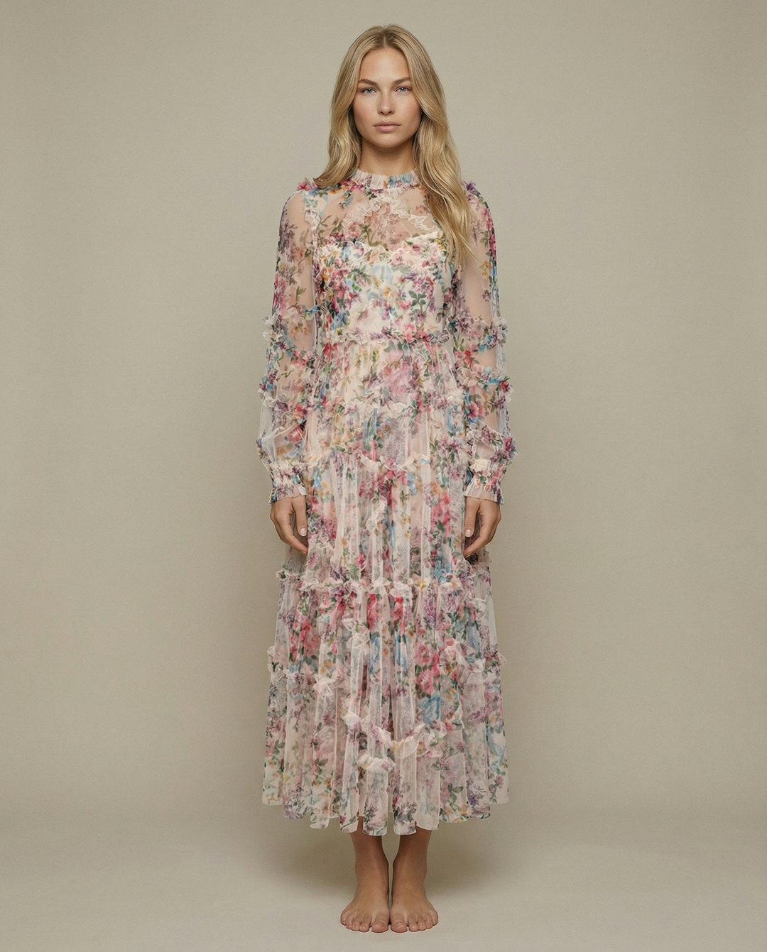 Woman wearing an apricot floral maxi dress with layered ruffle styling on a plain background.