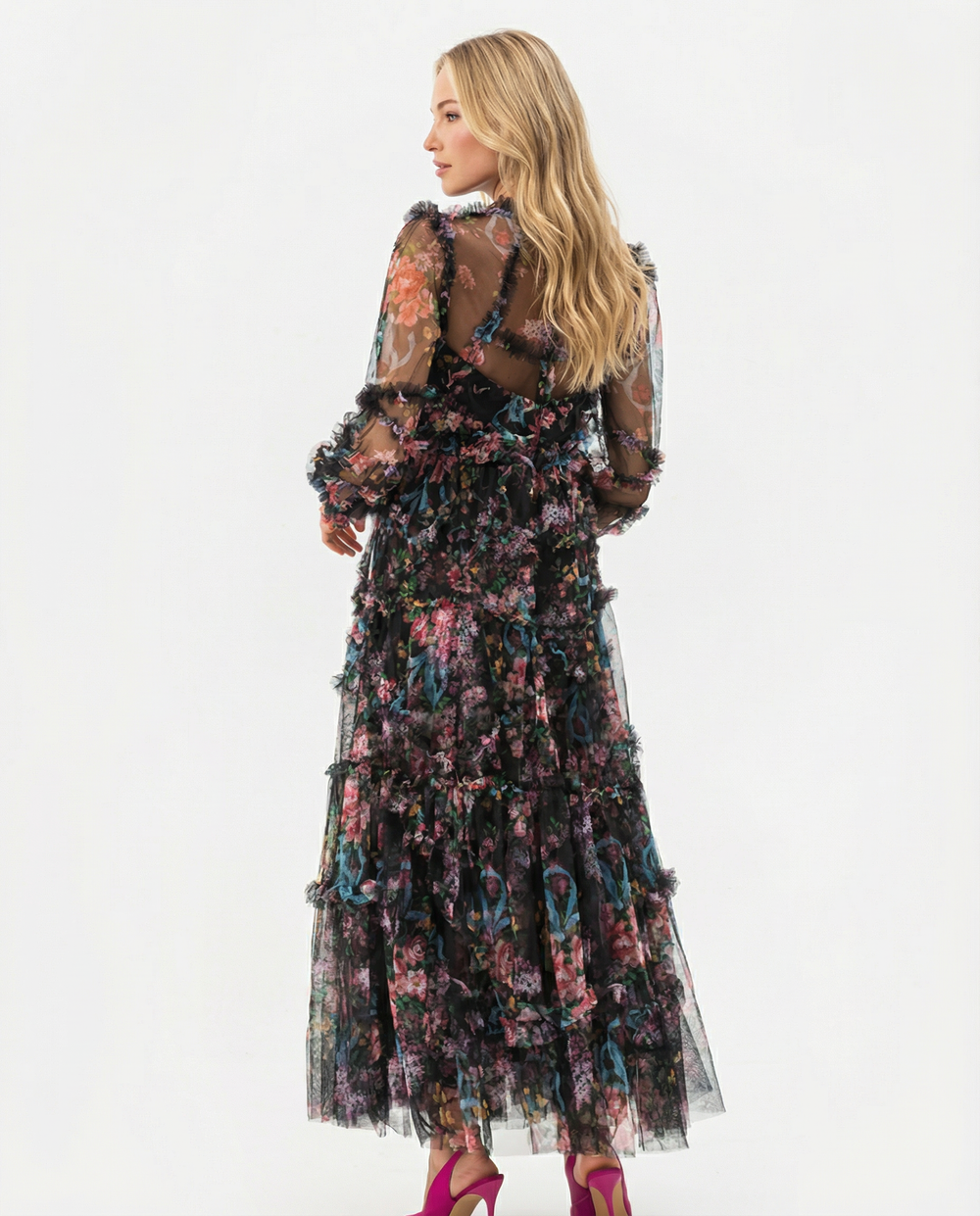 Woman in a layered floral maxi dress with a high neckline against a plain background.