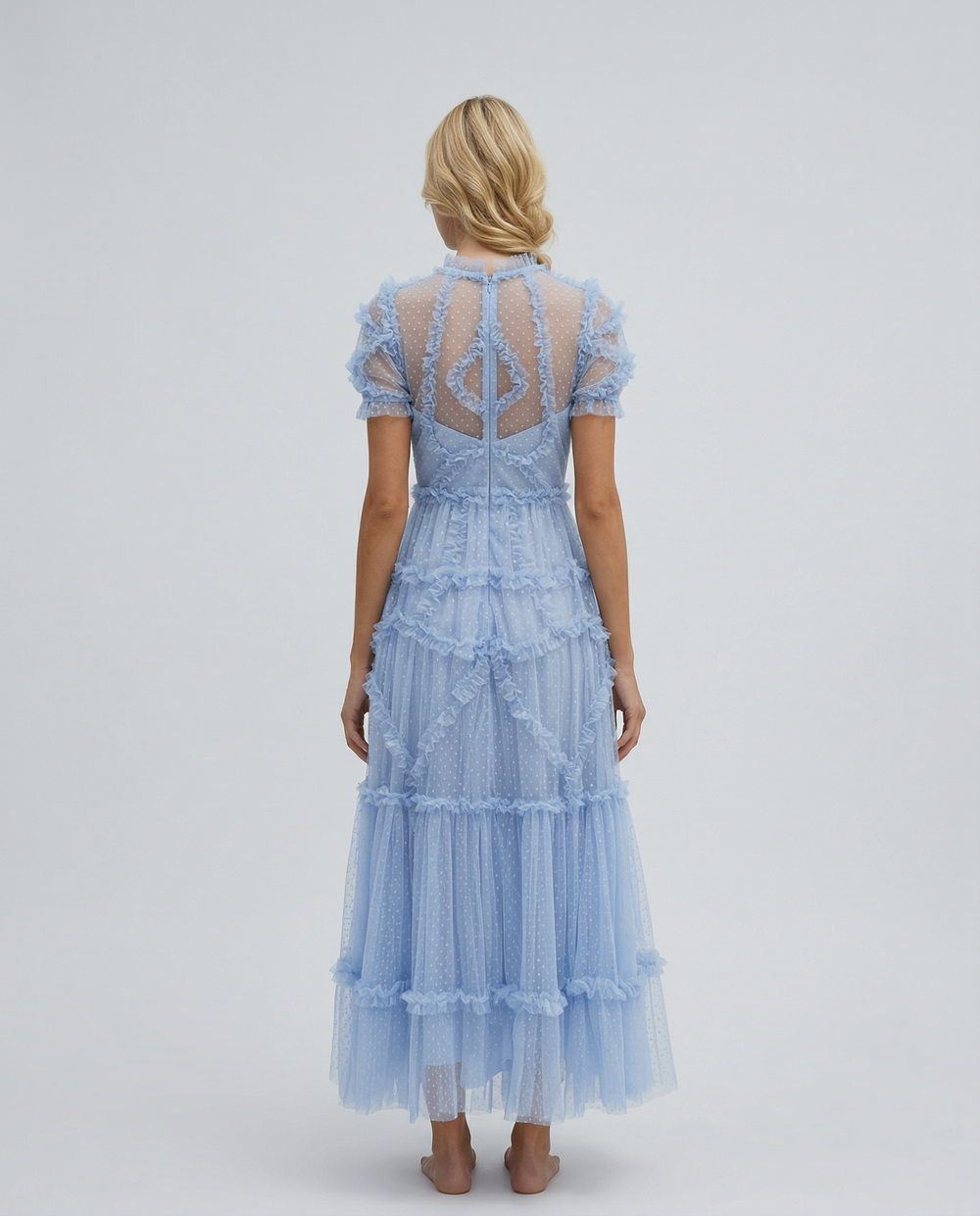 Female model in a high neckline maxi dress with short sleeves on a plain background.