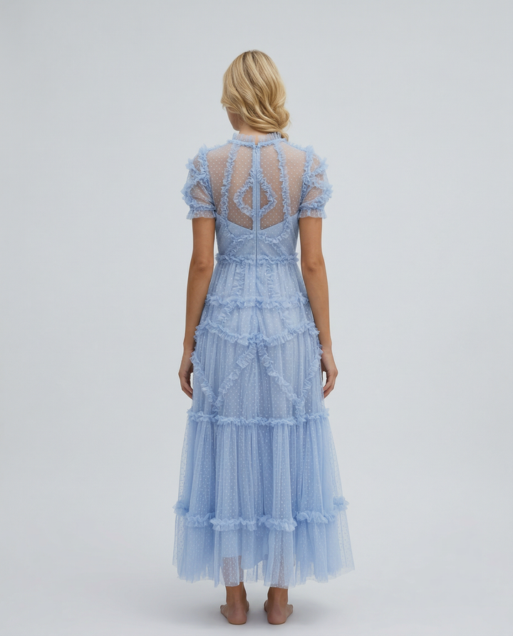 Female model in a high neckline maxi dress with short sleeves on a plain background.