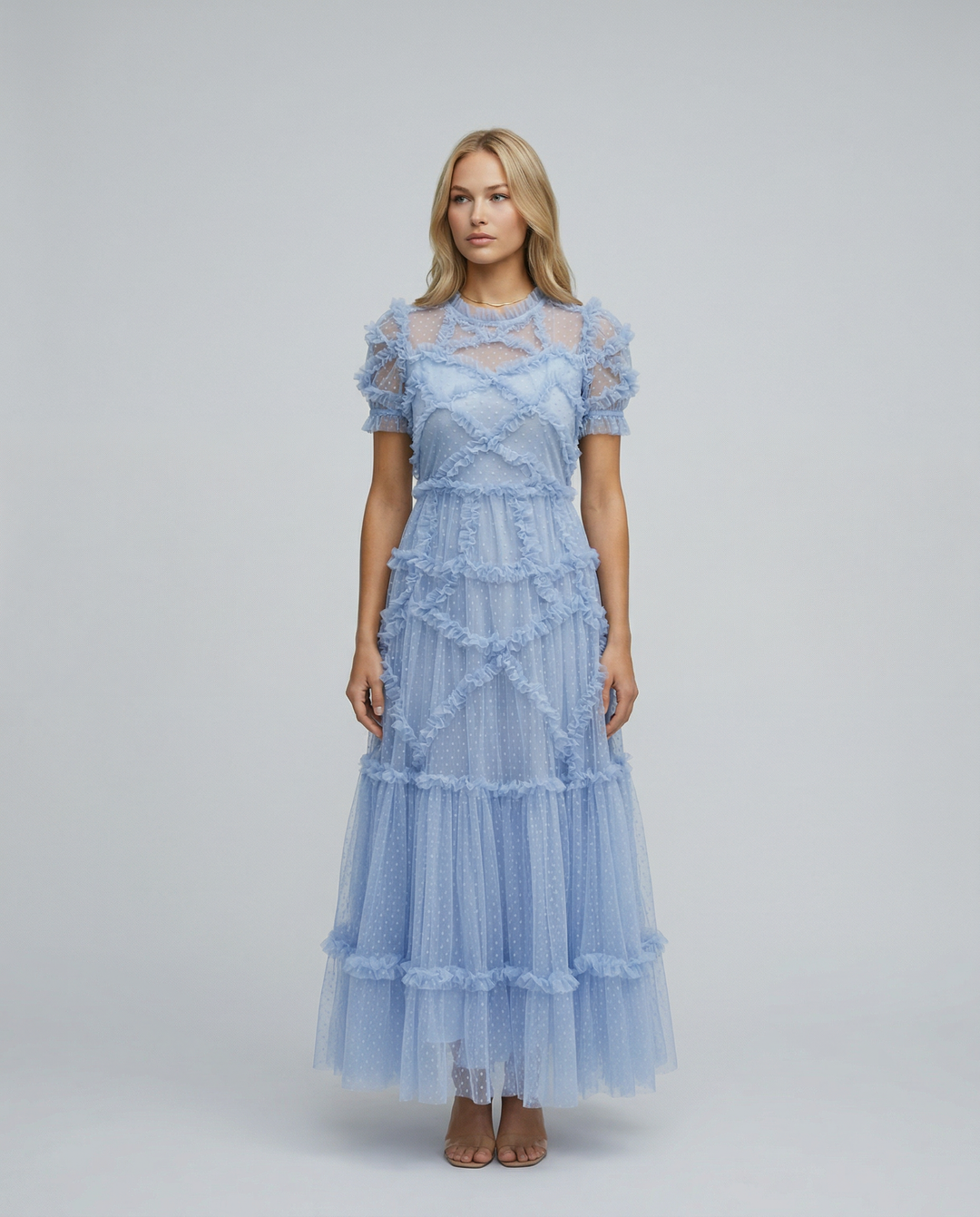 Woman wearing a tiered maxi dress with ruffle layers on a plain background.