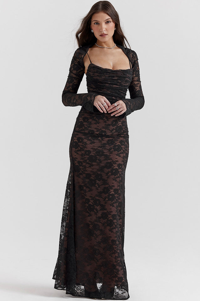 Female model wearing a black lace maxi dress with long sheer sleeves on a plain background.