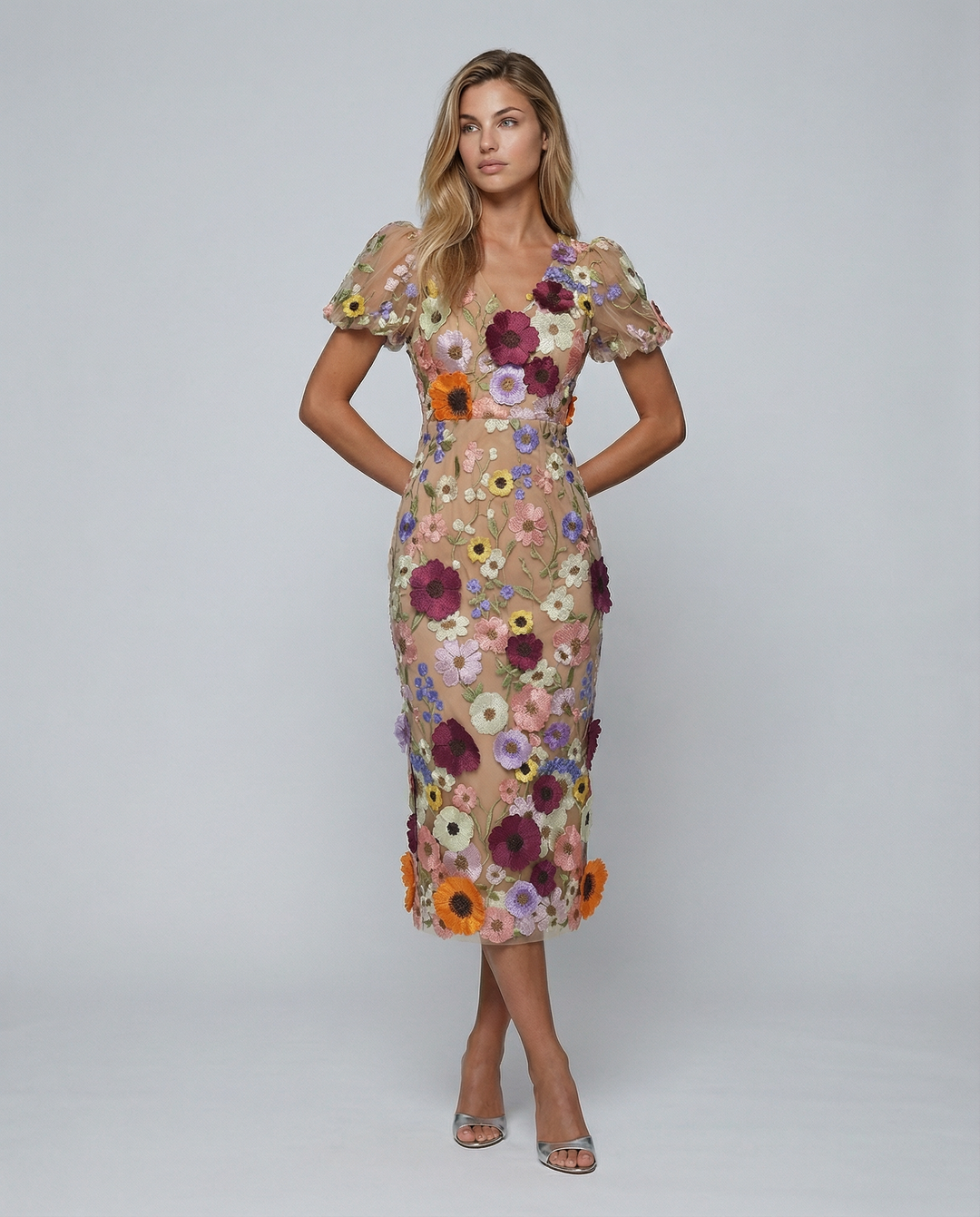 Female model wearing a floral embroidered midi dress on a plain background.