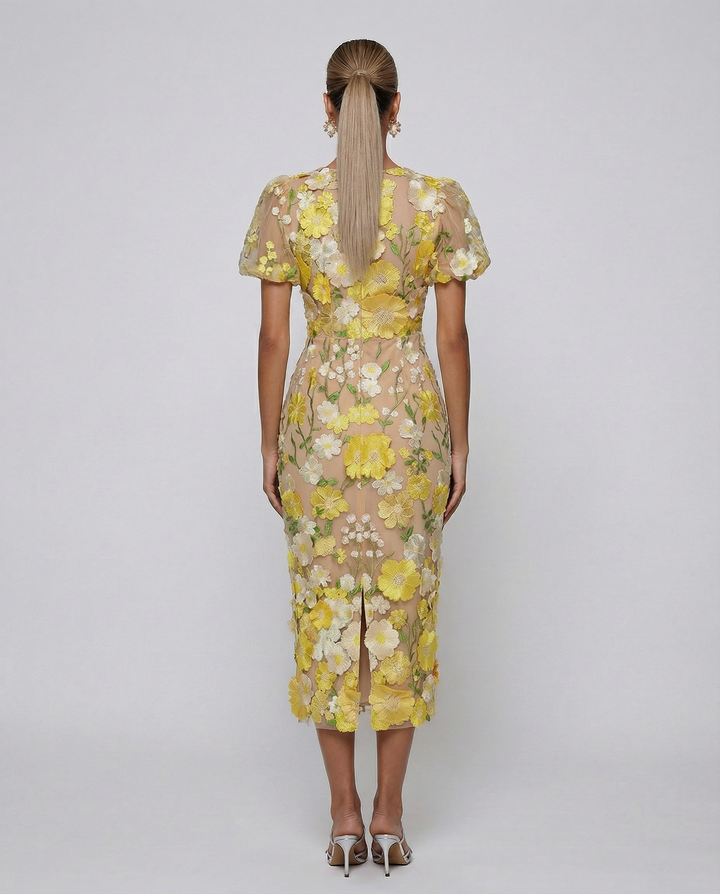 Woman wearing a calf-length floral dress with short sleeves on a plain background.