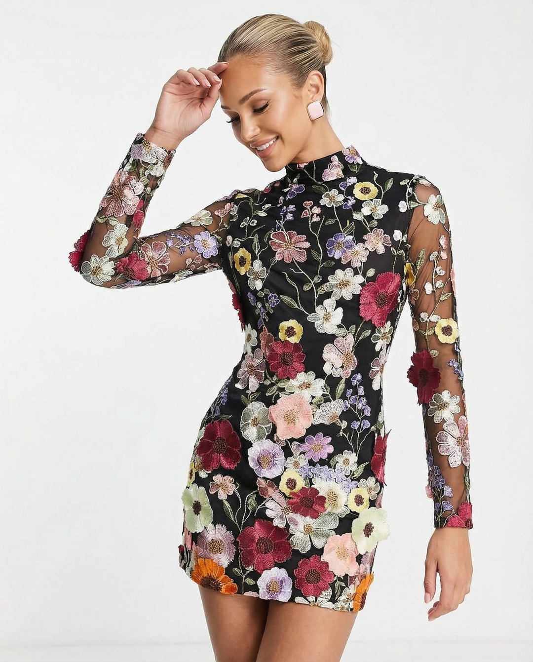 Female model wearing a beige embroidered mini dress on a plain background.