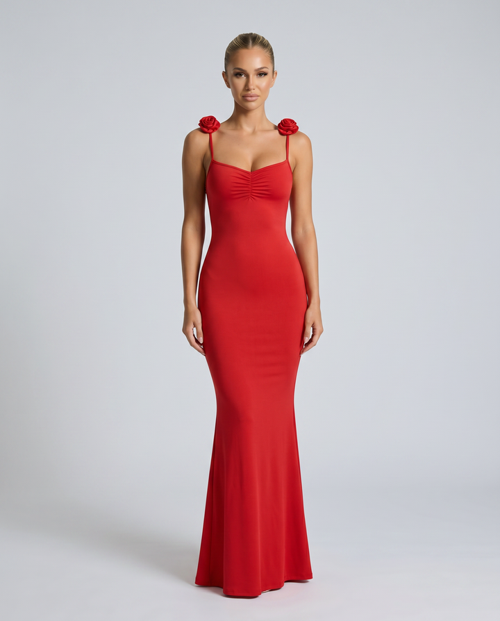 Female model wearing a flowing sleeveless maxi dress on a plain background.