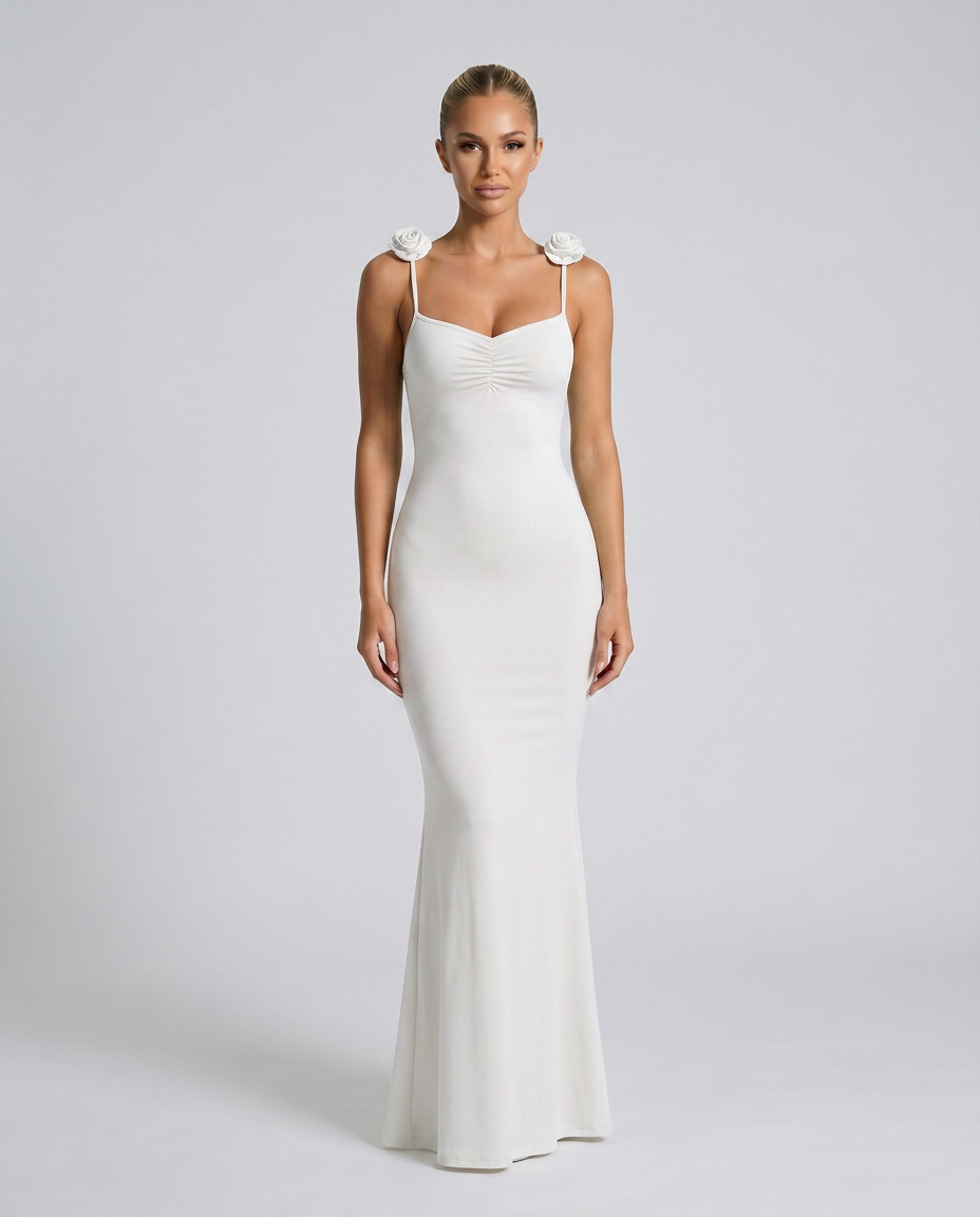 Female model wearing a white maxi gown with slim straps against a plain background.