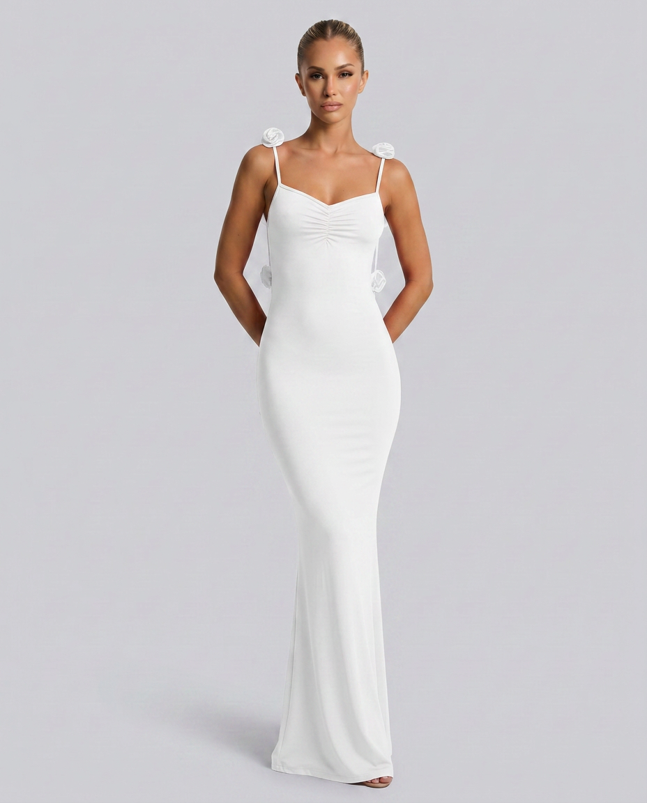 Model showing a scoop neckline white gown with delicate shoulder strap accents.
