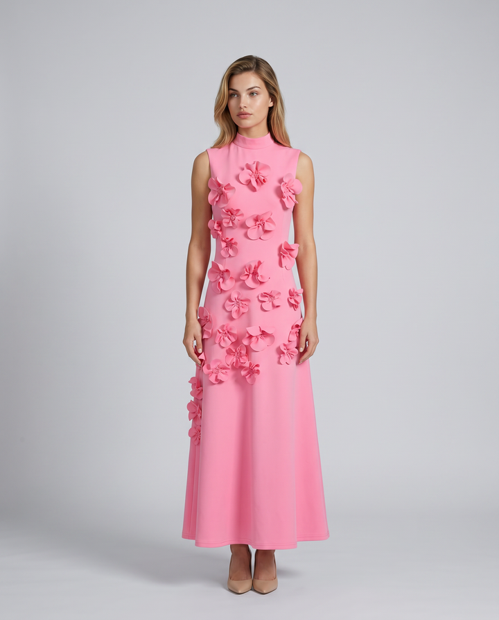 Female model wearing a sleeveless floral appliqué maxi dress on a plain background.