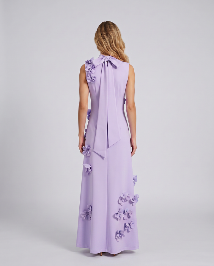 Woman wearing a sleeveless occasion dress with textured floral details.