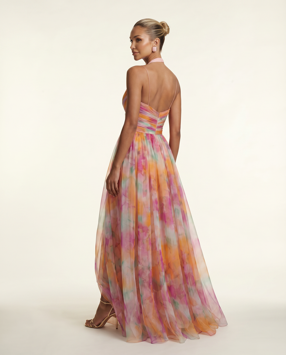 Woman in a sleeveless V-neck floral maxi dress standing against a plain background.