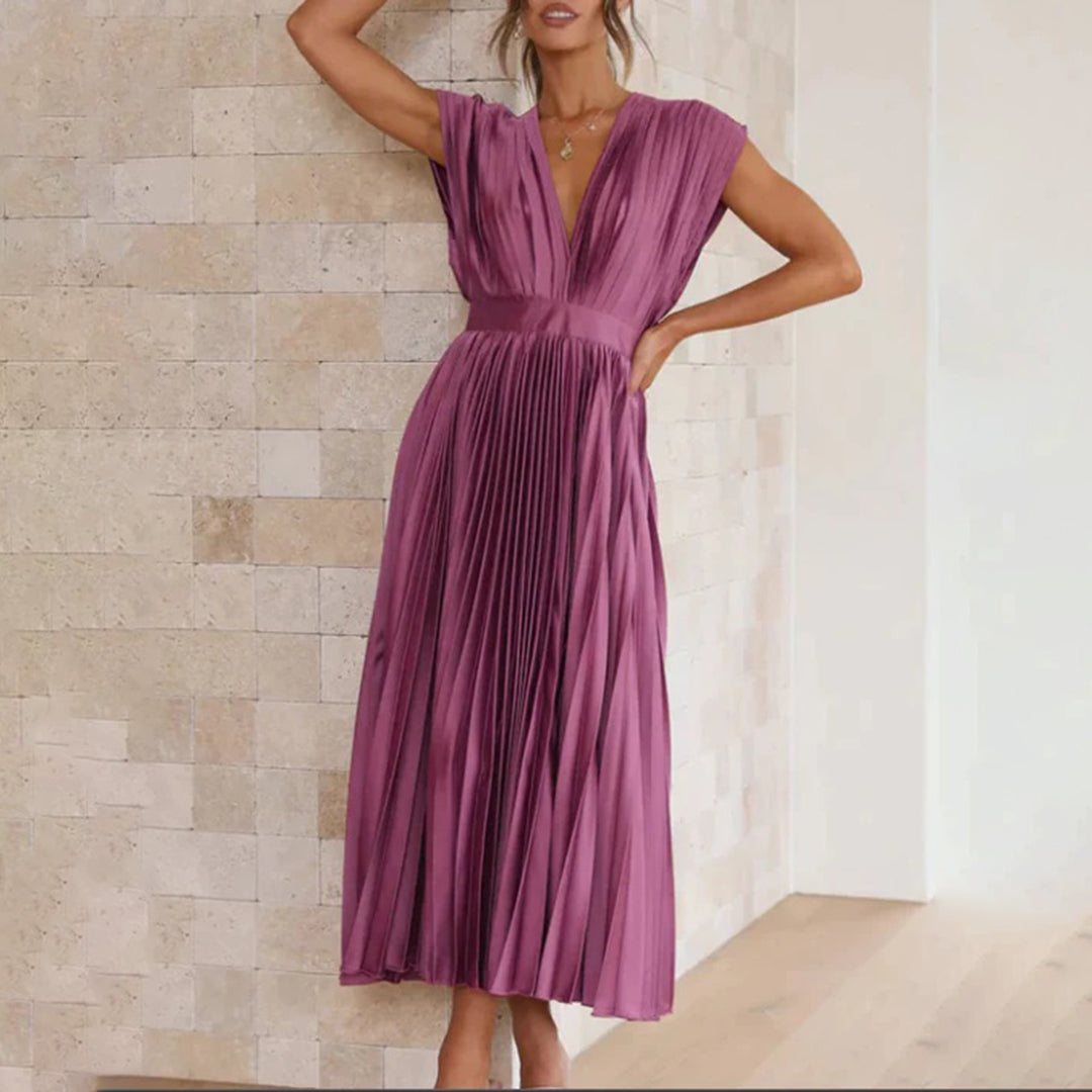 Model in a refined women’s dress with a plain background.