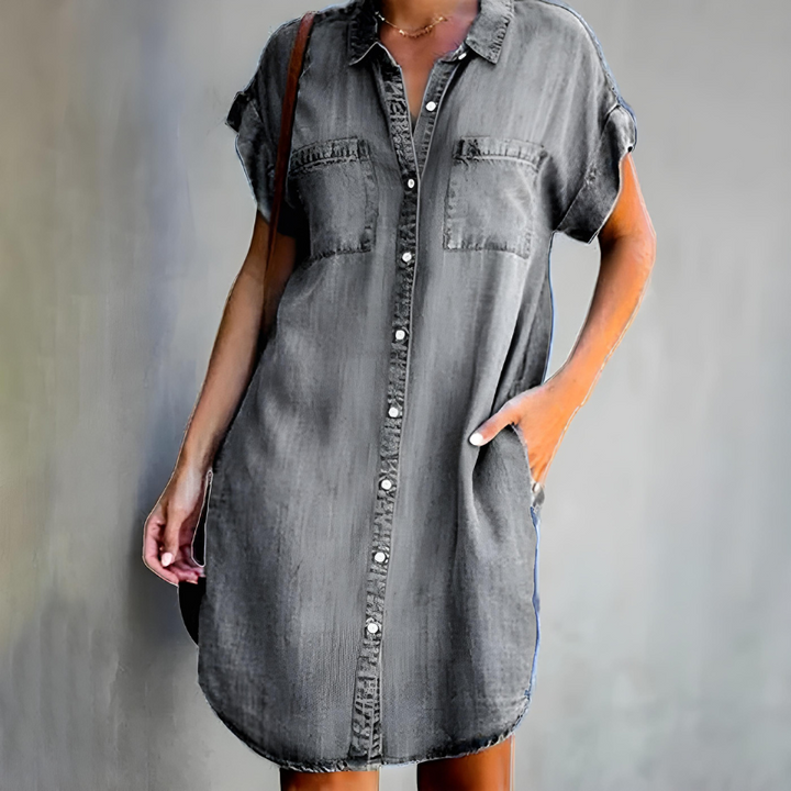 Female wearing a layered dress on a plain background.