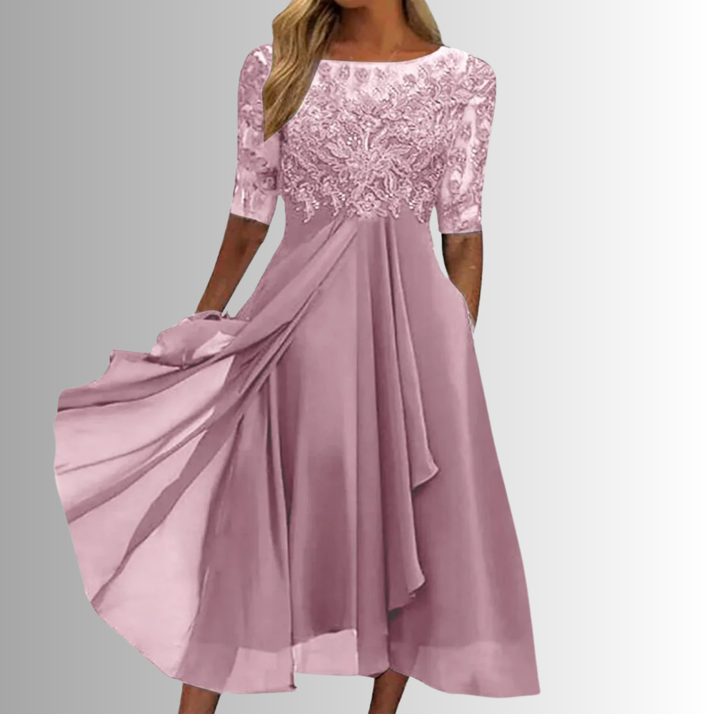 Woman in an elegant layered lace dress photographed on a plain background