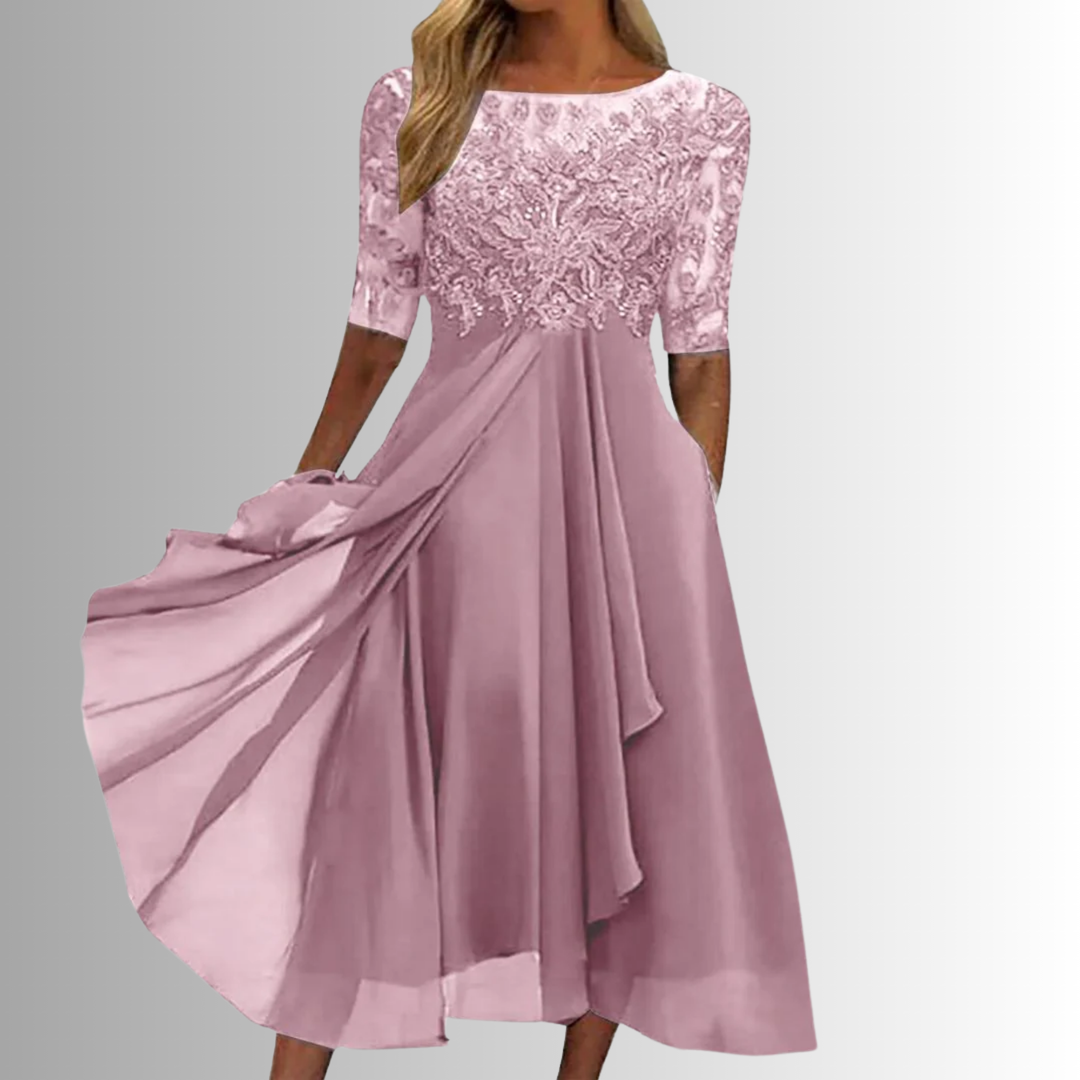 Woman in an elegant layered lace dress photographed on a plain background