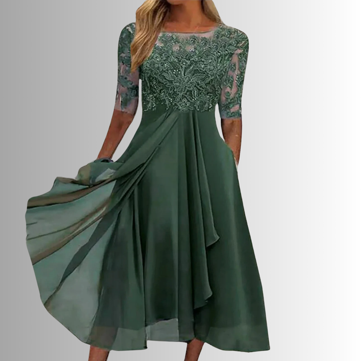 Woman wearing a sleeveless lace dress with layered skirt on a plain background