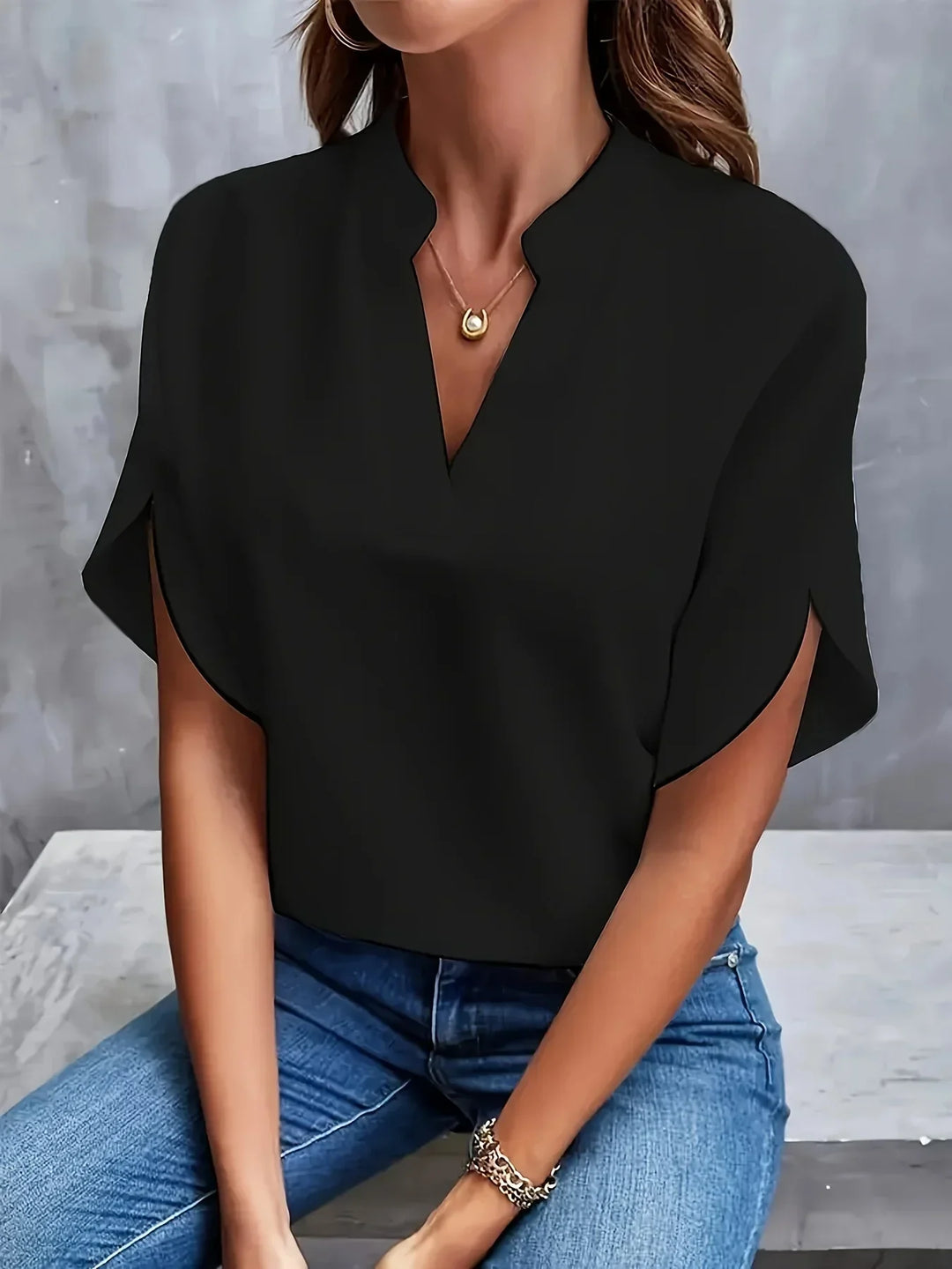 Elegant blouse worn by a model on a clean background focusing on tailored shaping.
