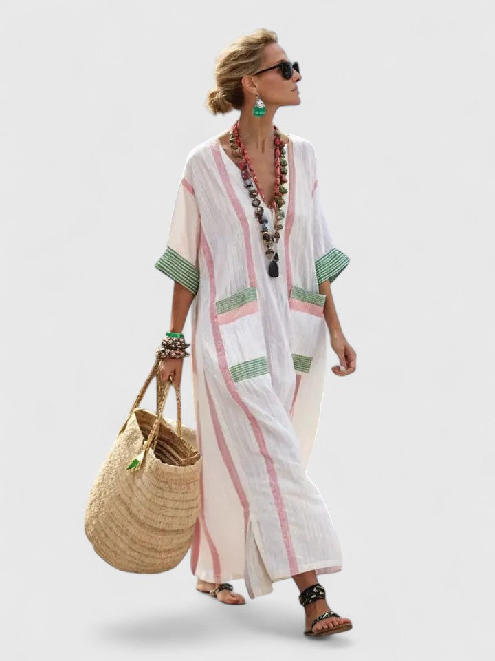 Female model wearing a striped kaftan maxi dress with a deep V-neck on a plain background.