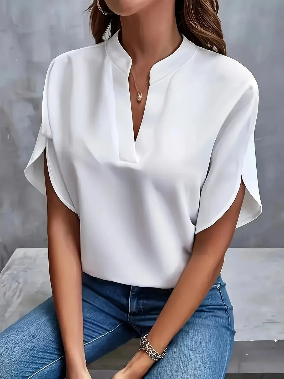 Polished blouse shown with a model on a clean background emphasizing a refined silhouette.