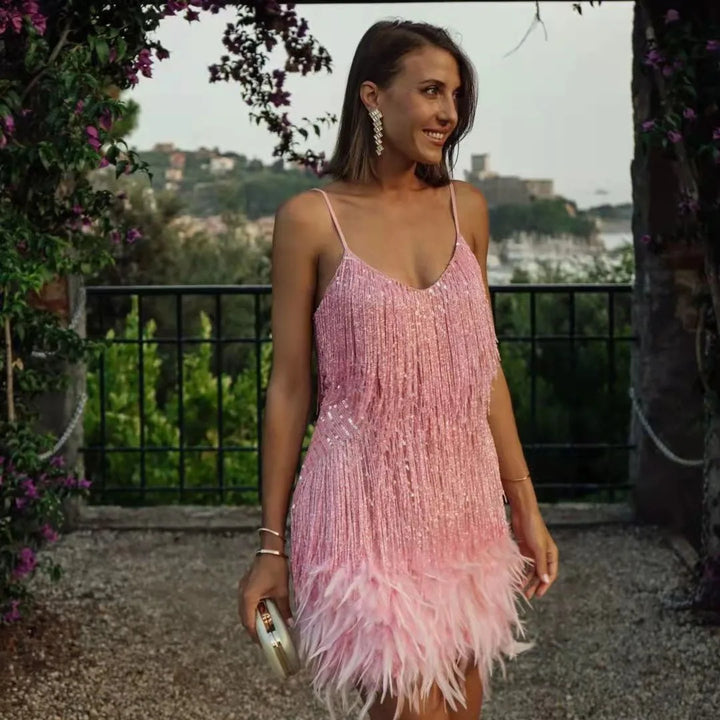 Female wearing a stylish sequin dress with flowing fringe detail against a nature backdrop.