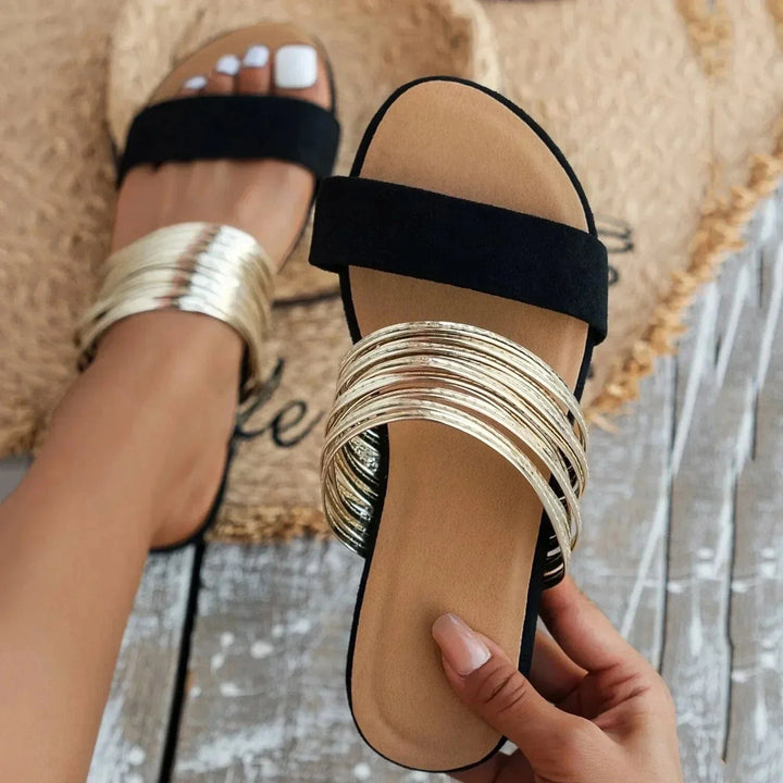 Foot wearing slip-on cushioned sandals on a plain background.