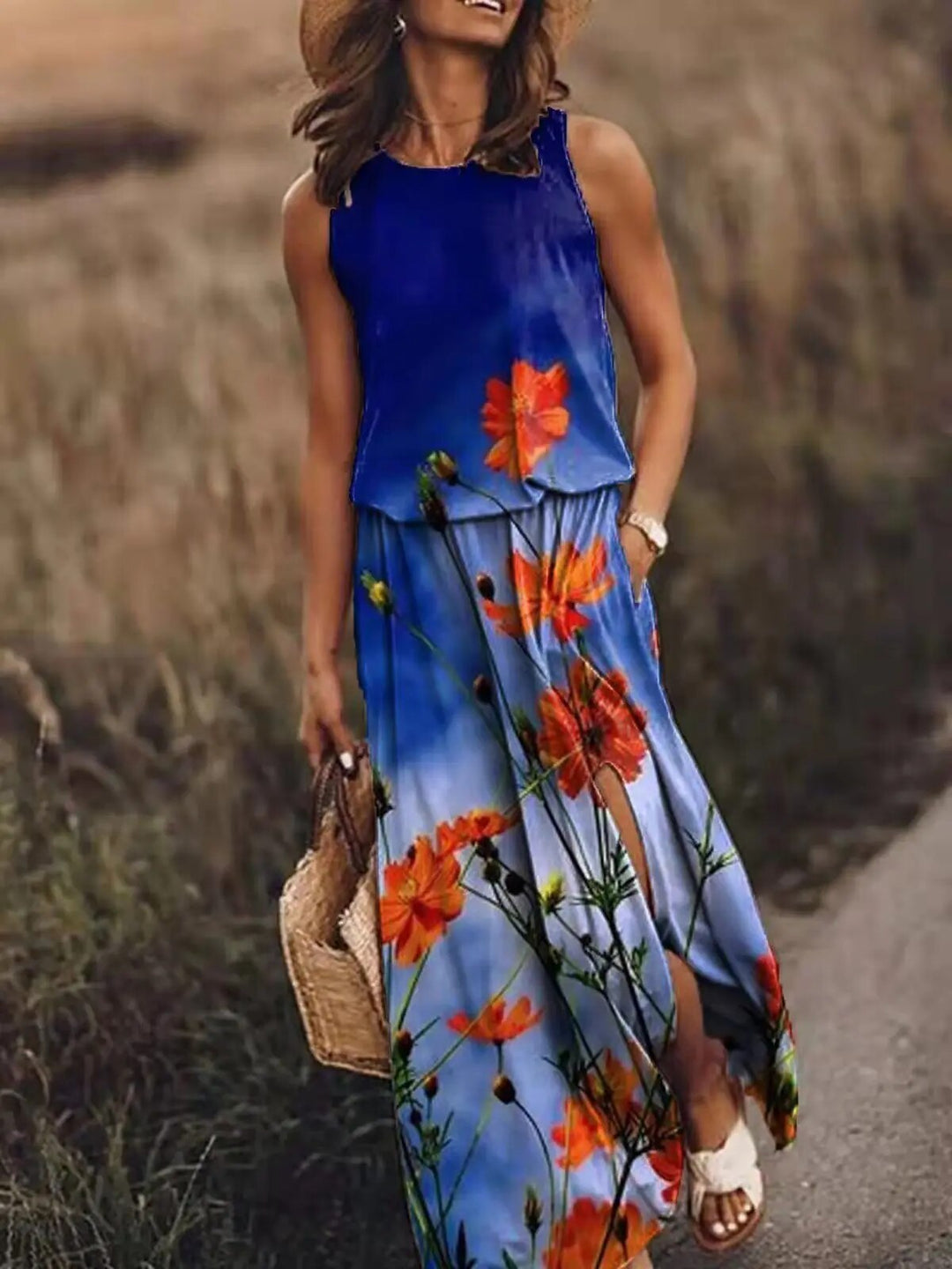 Woman posing in a sleeveless printed maxi dress on a plain background.