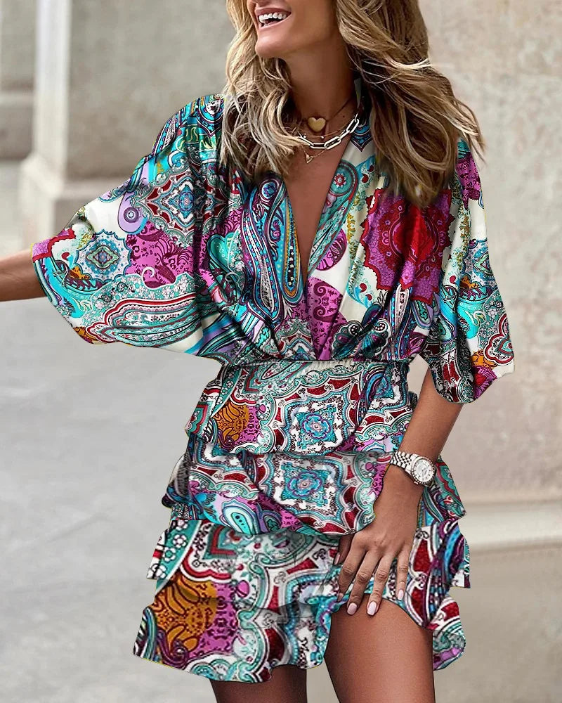 Colorful V-neck mini dress with elastic waist styled on a woman against a plain background.