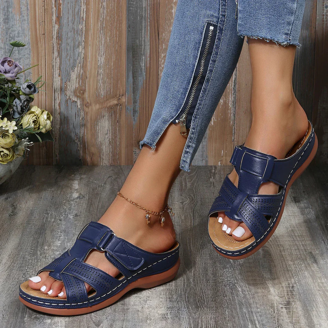 Female model highlighting wedge sandals with a stable heel design.