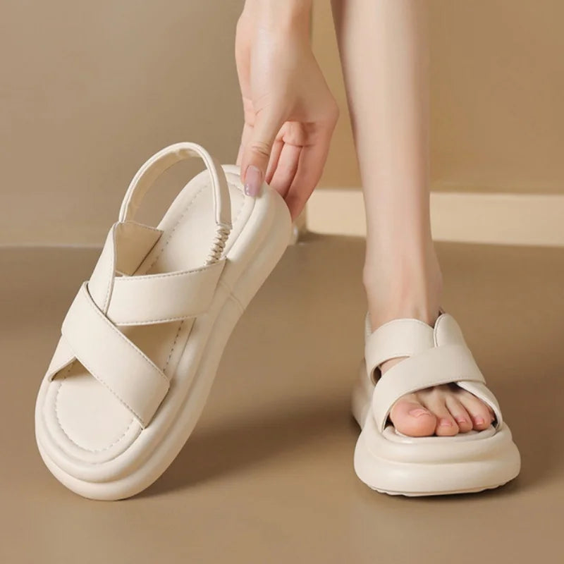 Female wearing casual wedge sandals with a soft insole against a plain background.