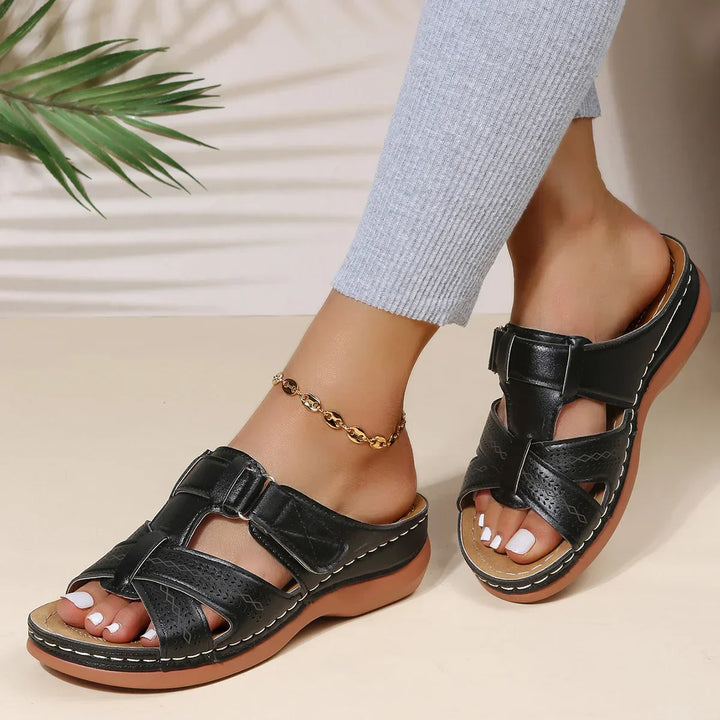 Female model wearing supportive wedge sandals with summer clothing.