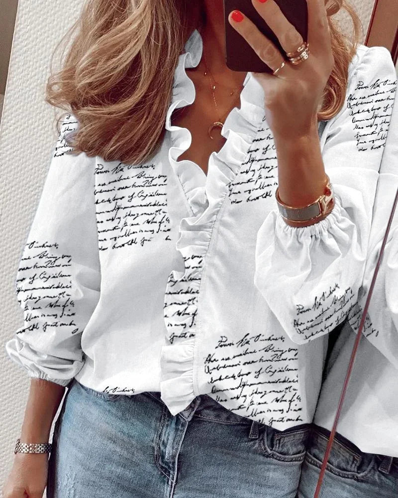 Relaxed fit blouse with gentle ruffles displayed on a person in a clean space.