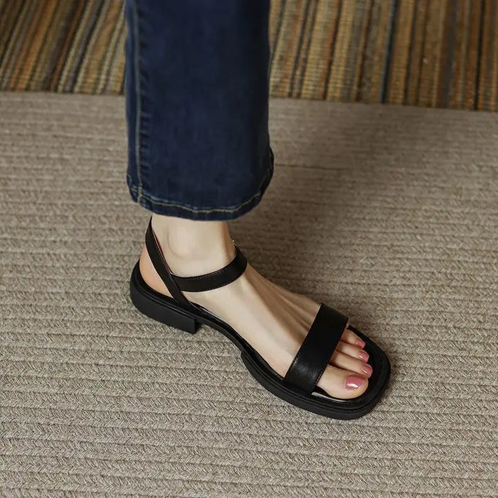 Women’s low block heel sandal shown from the side on a clean background.