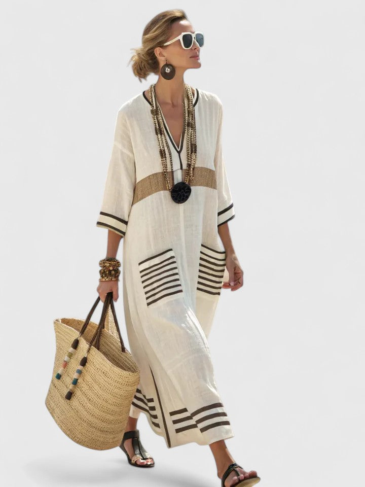  Woman in a flowing striped maxi dress with three-quarter sleeves on a plain background.